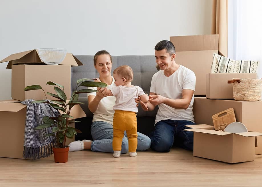 A young family unpacking moving boxes in their new home. — StoryTime Studio // Shutterstock