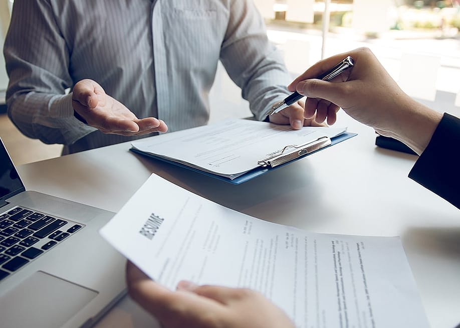 A job candidate explaining resume to a hiring manager. — wutzkohphoto // Shutterstock