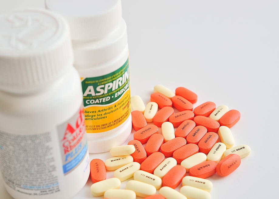 A bottle each of aspirin and ibuprofen pills — Icatnews // Shutterstock