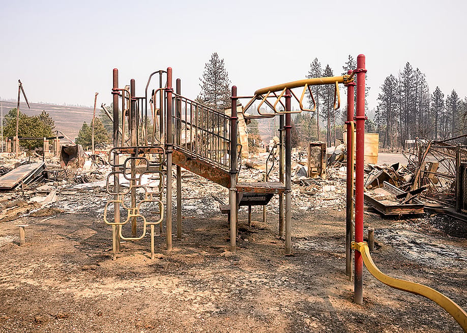 The burned remains of a playground are seen amidst the smoldering ashes of Riverside Real Life Church during the Old Trails fire in Spokane, Washington on August 4, 2026. — Josh Edelson // AFP via Getty Images