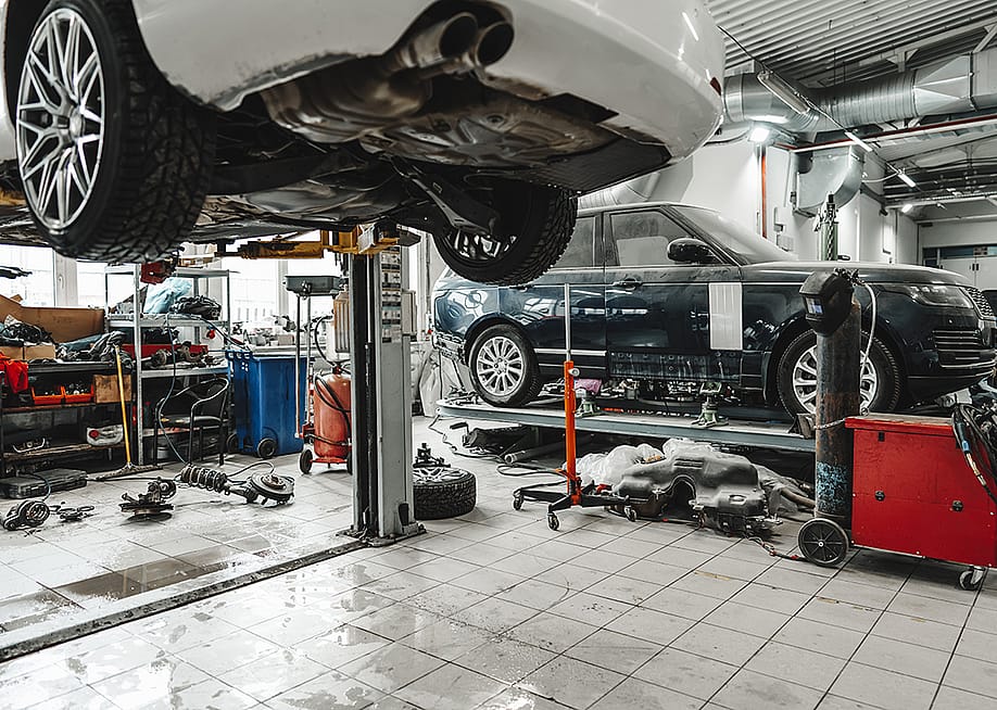 A car raised in a car lift in an auto repair shop. — FabrikaSimf // Shutterstock