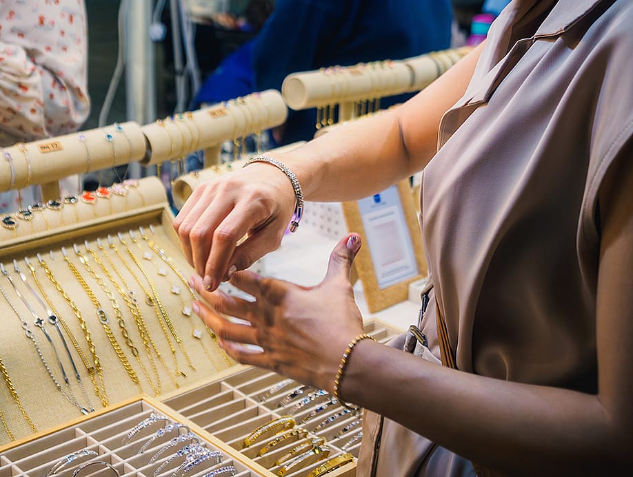 Close up of a woman trying on jewelry at a store. — Abzuraimi // Shutterstock