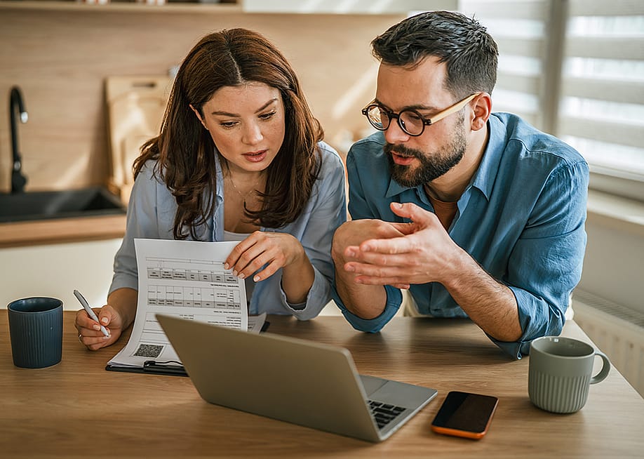 A young couple discussing management of finances. — Miljan Zivkovic // Shutterstock