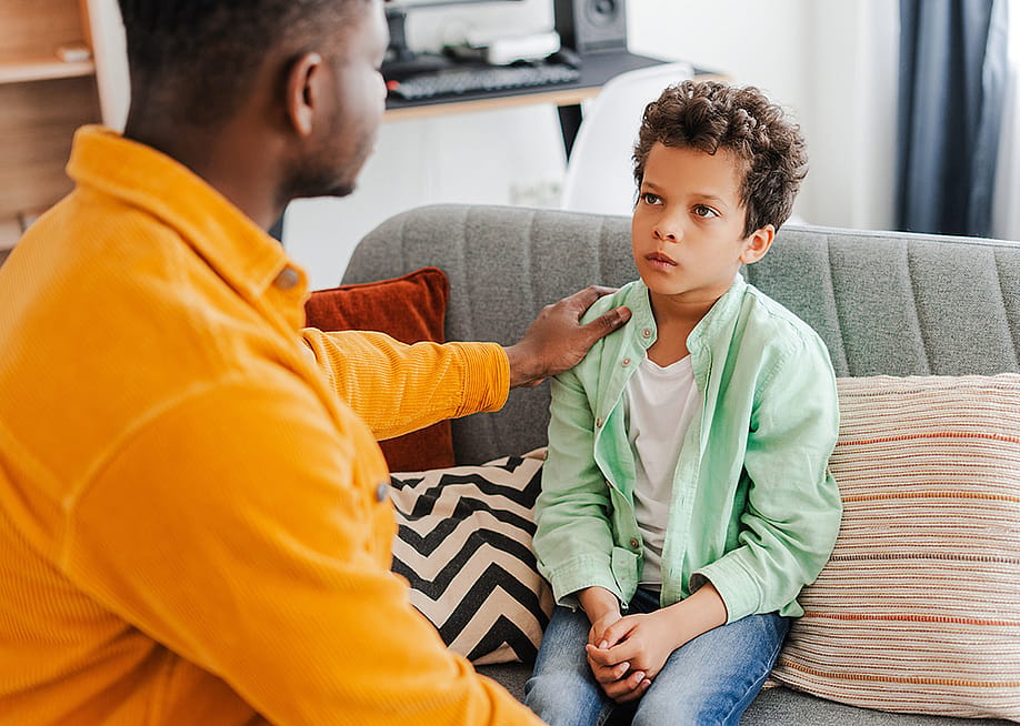 A father comforts his young son at home. — AYO Production // Shutterstock