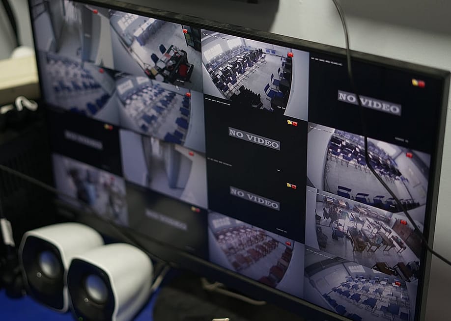 A monitor screen displaying a multi-view of CCTV footage with some units broken and showing no video. — Baangron // Shutterstock