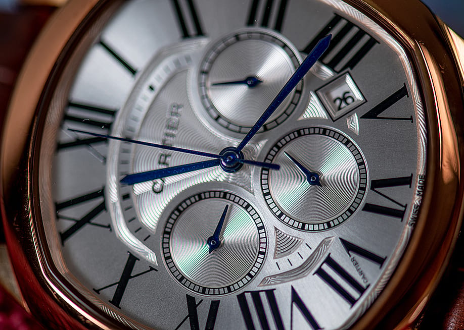 A close-up of a Cartier Drive de Cartier men's watch dial in golden steel color. — Q world // Shutterstock