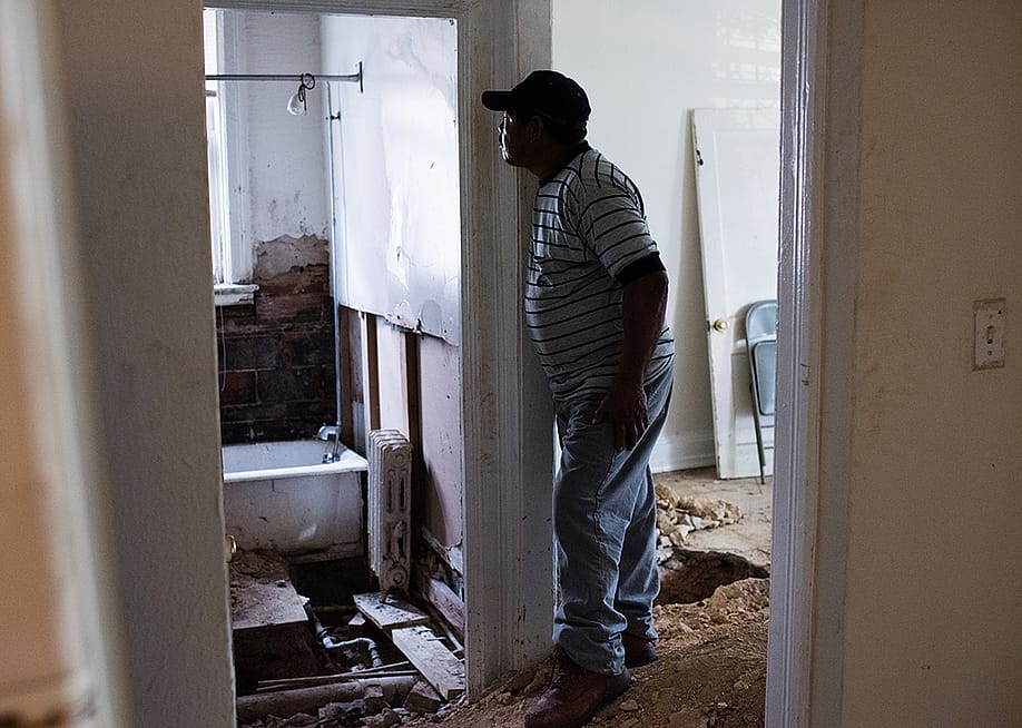 Javier Grijalva, 53, standing inside his first apartment in a building, which had crumbling walls, molds, and very hot pipes running through the floor. — Sarah L. Voisin // The Washington Post via Getty Images