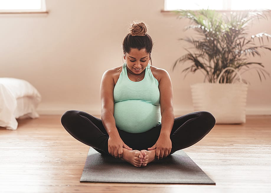 A pregnant woman doing yoga at home — Jacob Lund // Shutterstock