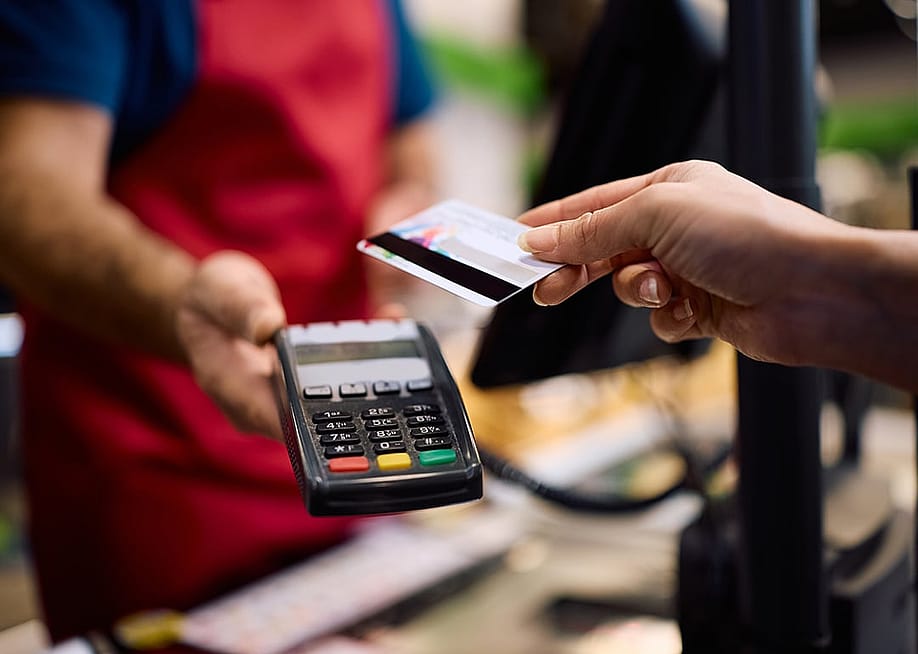 Customer paying with a card at a supermarket. — Drazen Zigic // Shutterstock