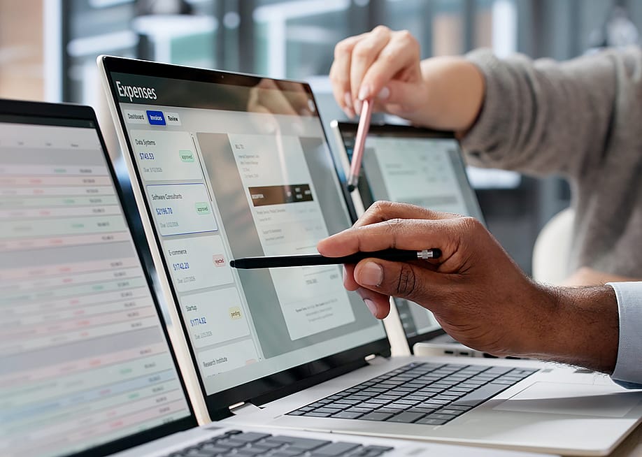 Finance employees reviewing expenses on a computer screen. — Andrey_Popov // Shutterstock