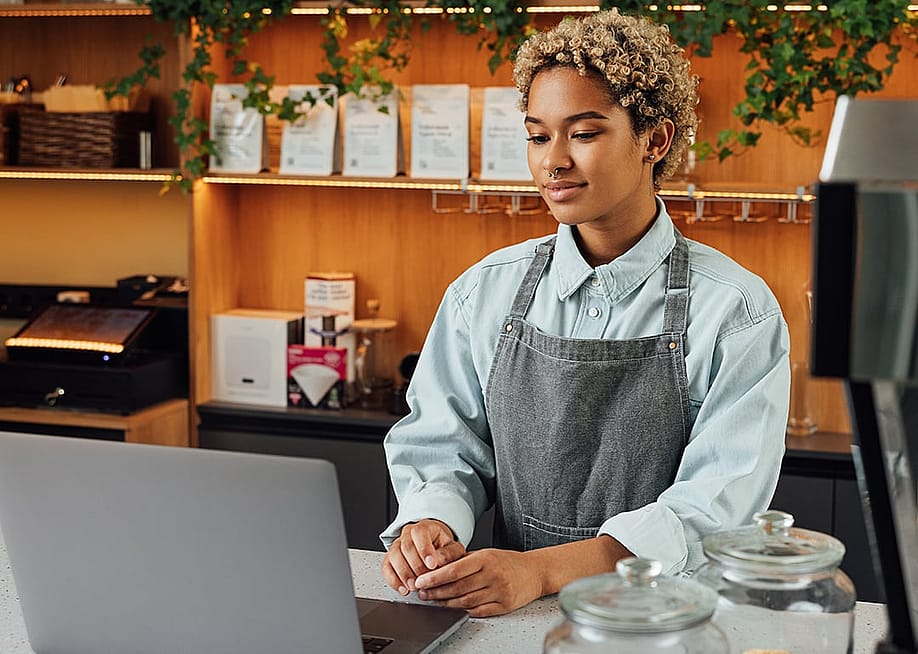 A café owner reviewing business insurance options on her laptop during a short break. — Artem Varnitsin // Shutterstock