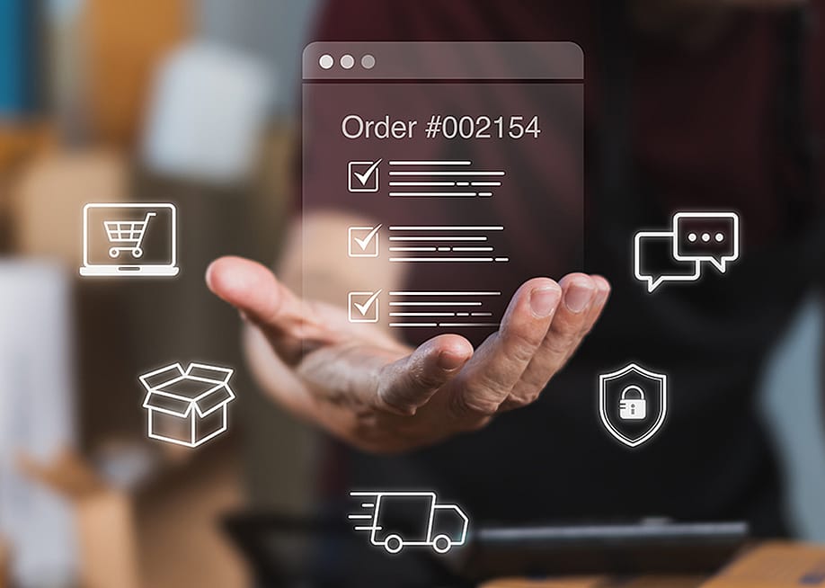 A worker checking digital order checklists surrounded by shipping packages. — thanmano // Shutterstock