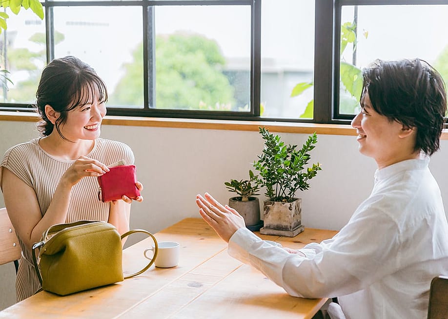 A young couple on a date where the woman gestures to offer payment. — buritora // Shutterstock