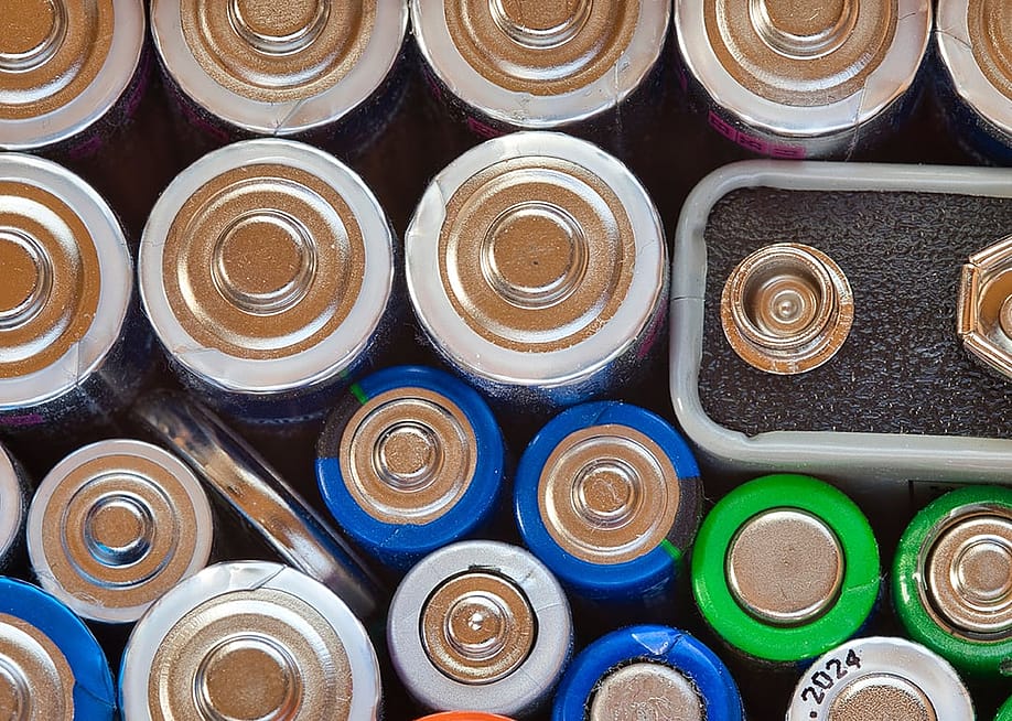 A close-up view of mixed-shaped household batteries. — Wirestock Creators // Shutterstock