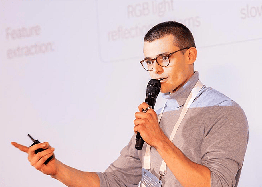 Filippo Nigro, the co-founder of You(th) giving a presentation holding a microphone. — You(th)