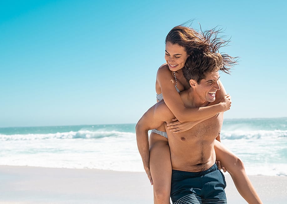 A young couple enjoying their vacation at a beach. — Ground Picture // Shutterstock