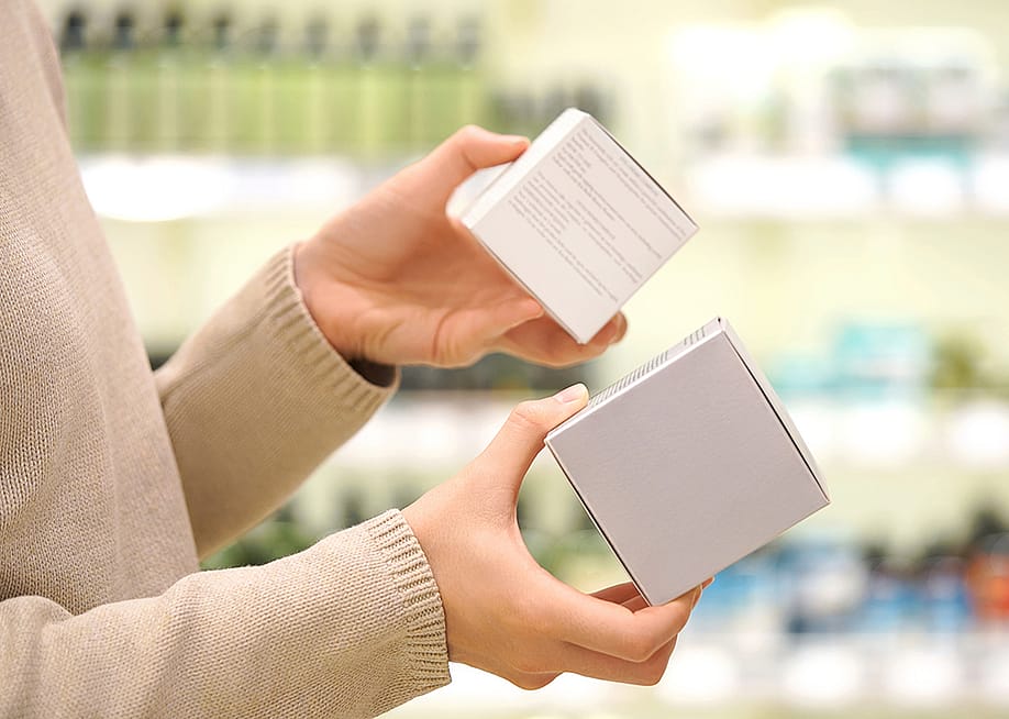 Person shopping for skincare items reading ingredient labels. — Alive Color Stock // Shutterstock