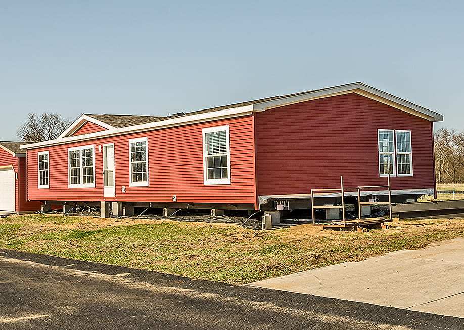 A new manufactured home with bright red exterior. — Sue Smith // Shutterstock