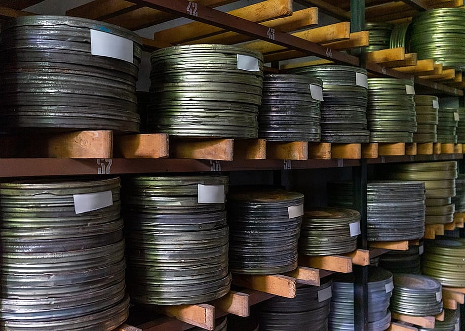 Stacks of metallic film reels on wooden shelves. — Voroshchuk // Shutterstock