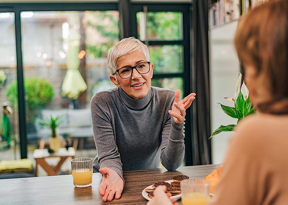 A middle-aged woman talking to her adult daughter at home. — Branislav Nenin // Shutterstock