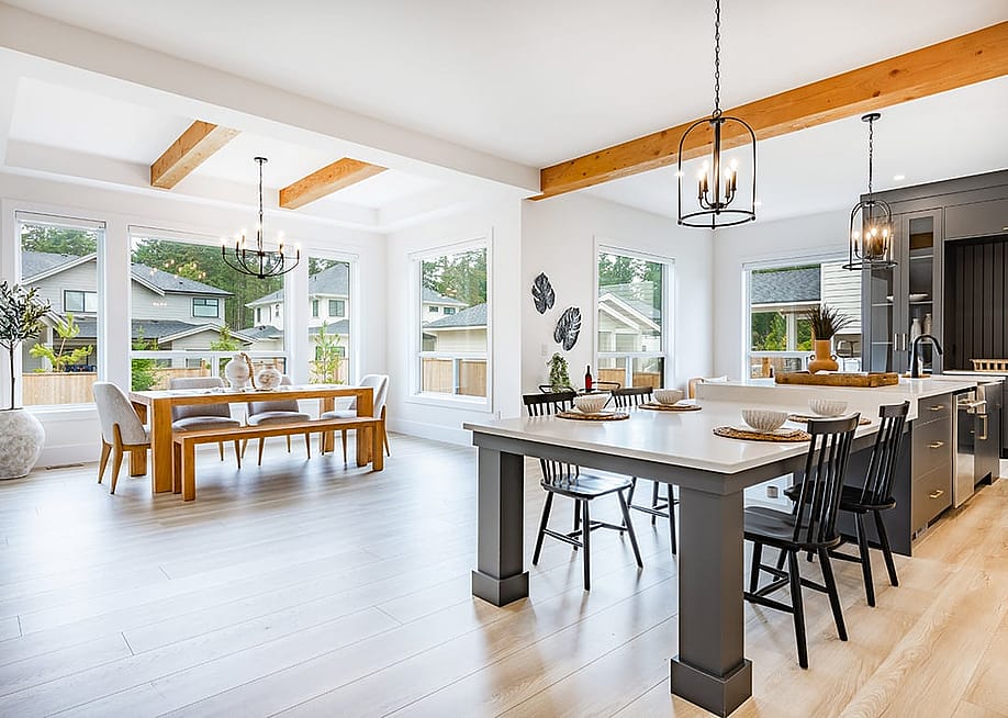 An interior of a modern home's living area, dining, and kitchen with its large glass windows. — Sheila Say // Shutterstock