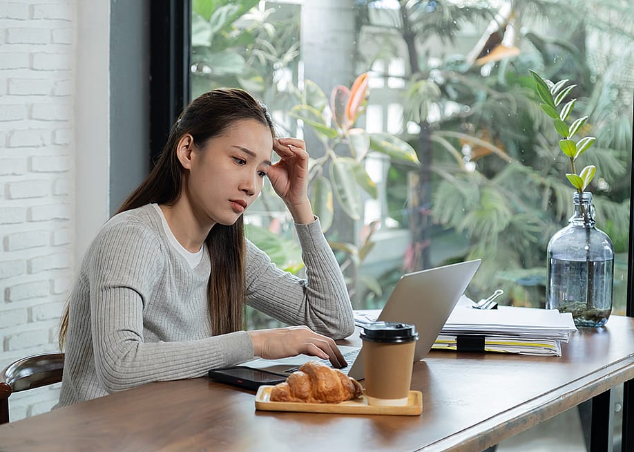 A female small business owner anxious in reviewing documents. — Simplylove // Shutterstock
