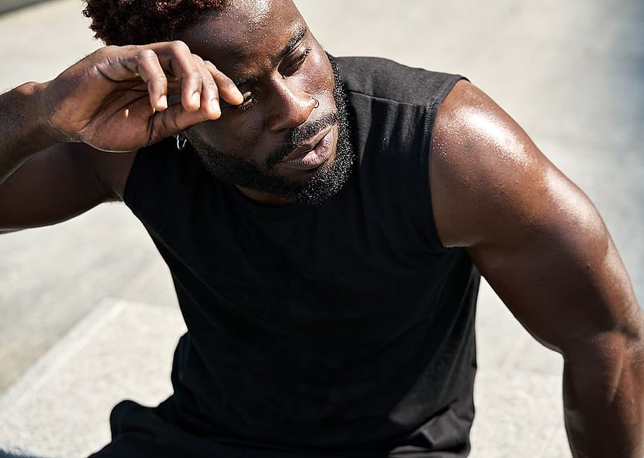 A fit young man in sportswear sweating after a workout in a park. — insta_photos // Shutterstock