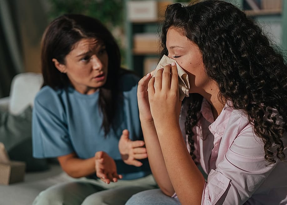 A woman showing support to her friend who is crying. — Miljan Zivkovic // Shutterstock