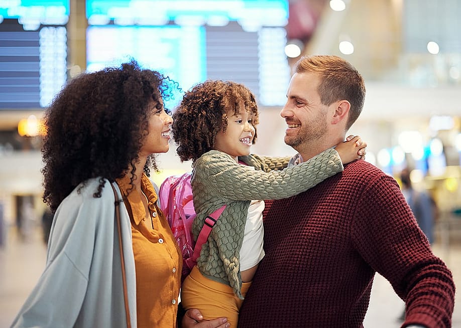 A family gathering in the arrival hall after stepping off their flight for vacation in the airport. — PeopleImages // Shutterstock