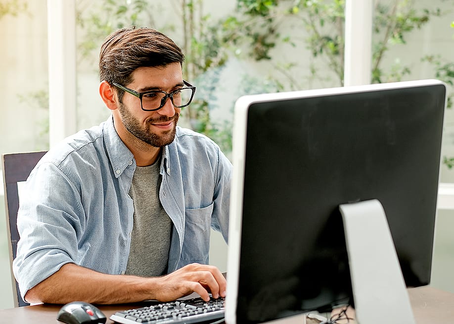 A person checking his credit reports and scores through a free source website on his desktop computer. — SritanaN // Shutterstock