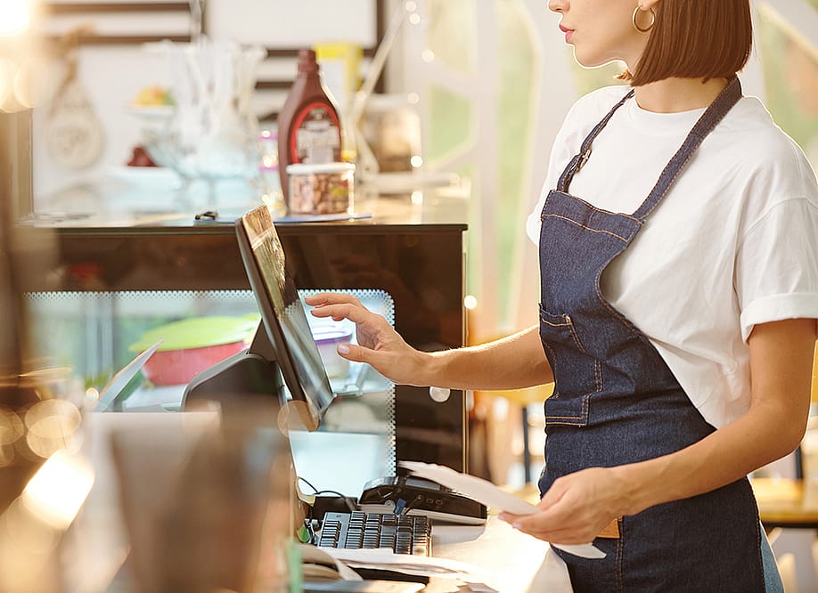 A female barista working at the counter of a coffee shop. — Dragon Images // Shutterstock