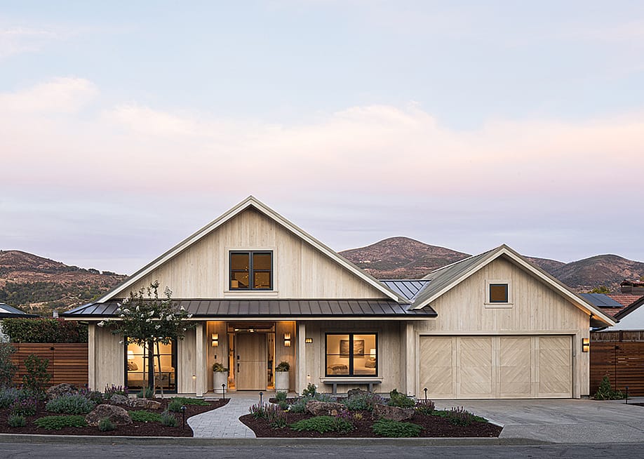 Exterior of home designed in beige color palette with dusky sunset and low mountains in the background. — Design: Sarahliz Lawson; Architect: Luke Clark Tyler – Field Issue Design; Photo: Adam Potts