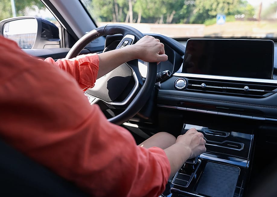 A person driving behind the steering wheel of a modern car. — Africa Studio // Shutterstock