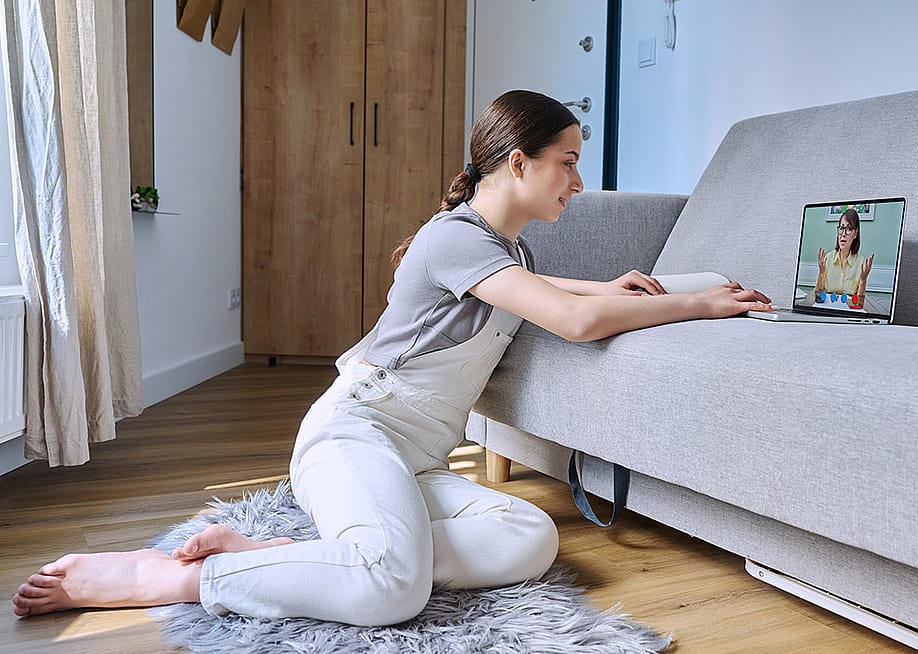 A young adult listening to a psychologist during an online therapy session at home. — VH-studio // Shutterstock