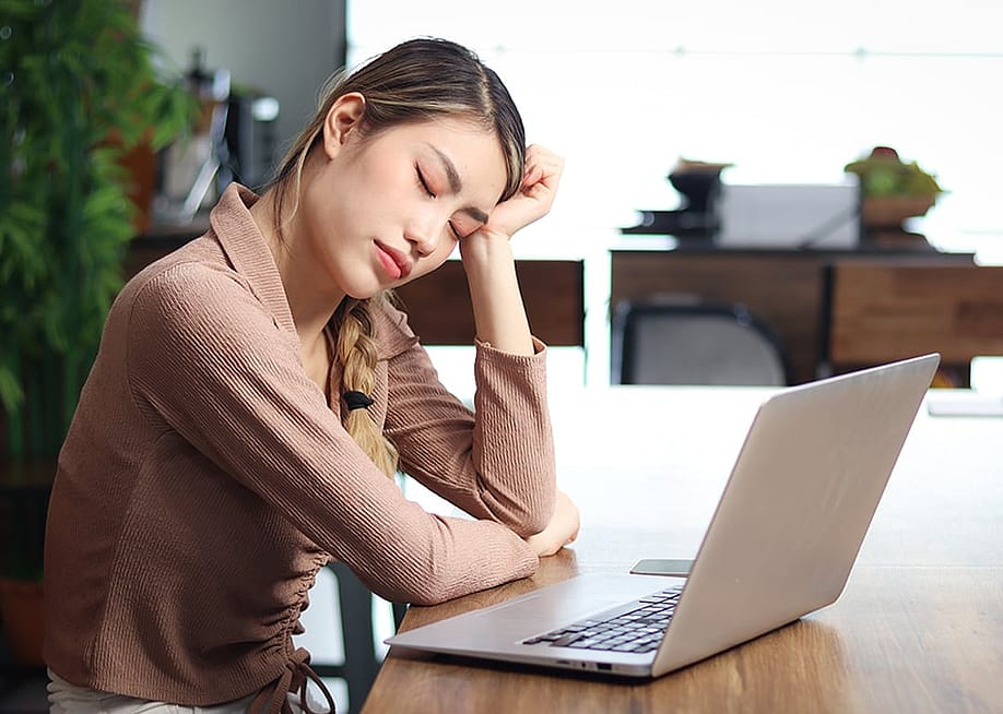 A stressed office worker closing her eyes while taking a short break from work at the office. — Stella_E // Shutterstock