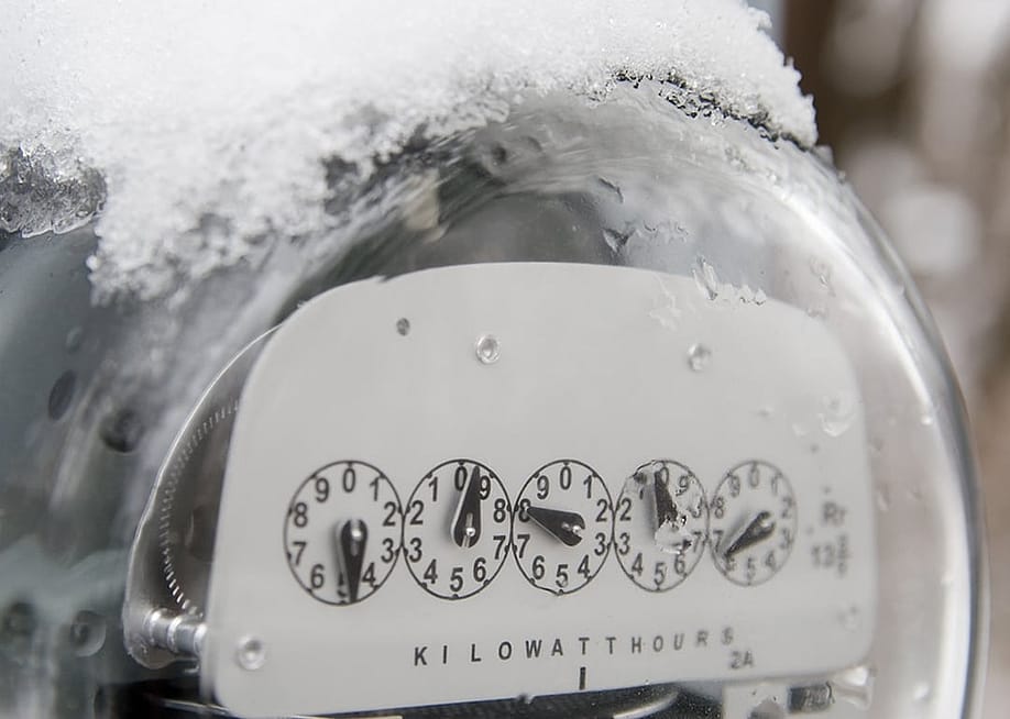 An electric utility meter with snow ice on the top of it. — Keith Lamond // Shutterstock
