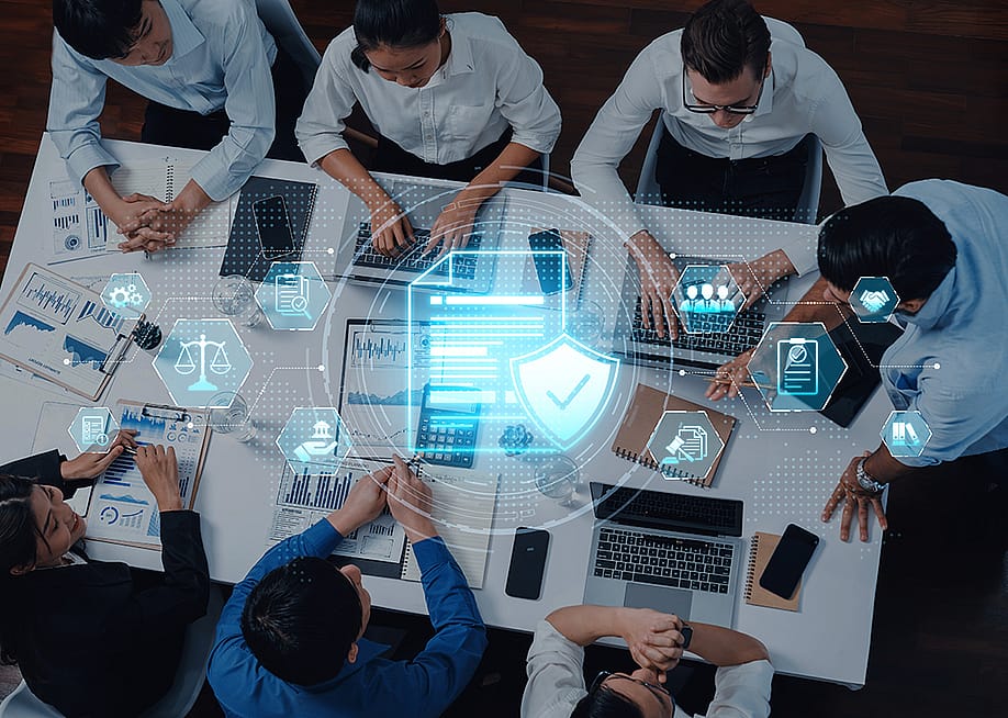 A IT team collaborating on a digital security strategy in a modern office. — Summit Art Creations // Shutterstock