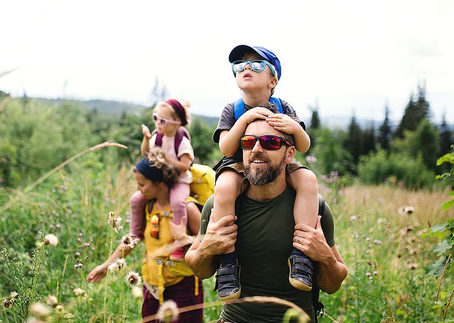A family hiking outdoors in the summer nature. — Ground Picture // Shutterstock