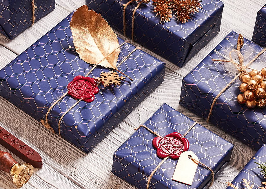A flatlay of creatively wrapped and decorated holiday boxes arranged in a surface. — haveseen // Shutterstock