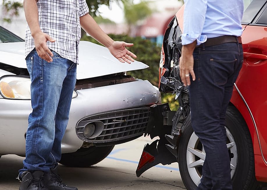 Two drivers talking and arranging a repair settlement for their vehicles after an accident. — Monkey Business Images // Shutterstock