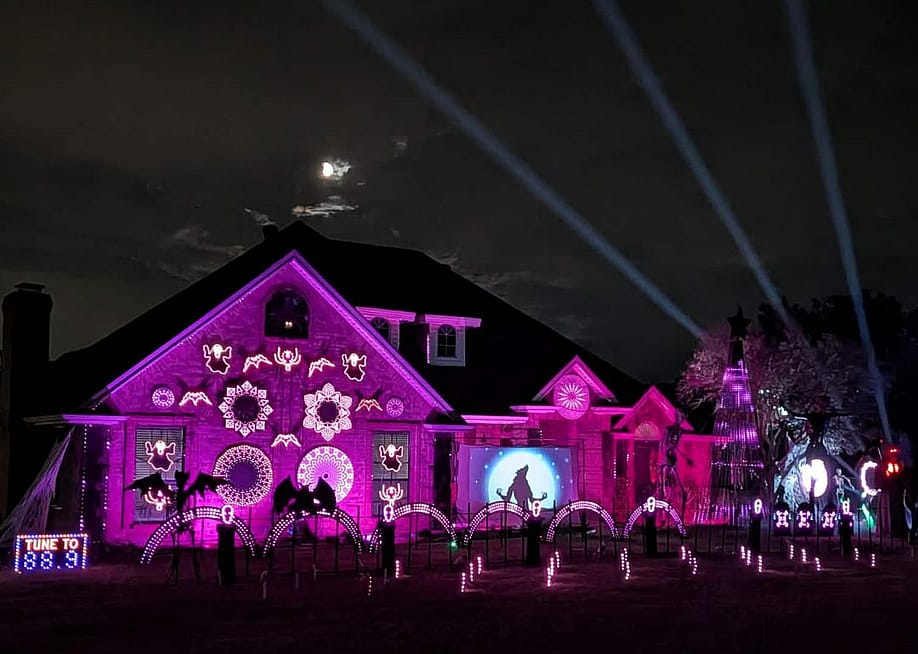 Night time display of house with Halloween light show using programmable RGB lights projected with the help of software, sequencing, controllers, wiring, and hardware. — Courtesy of Olga and Kenneth Neumann