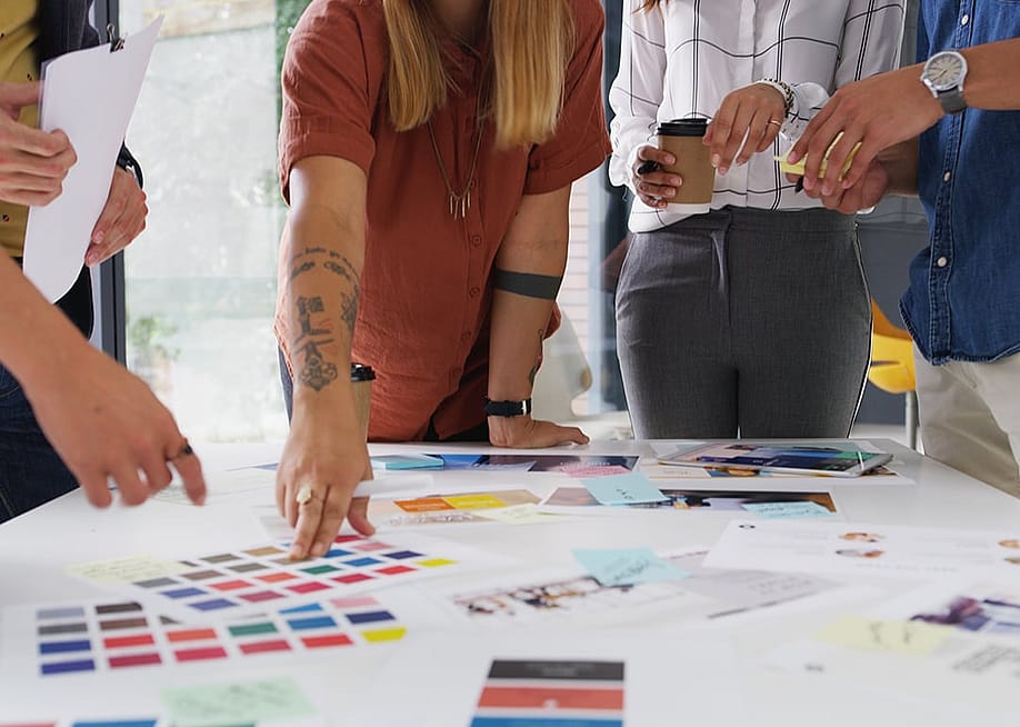 A design team collaborating on color swatches for a brand choice and approval. — PeopleImages // Shutterstock