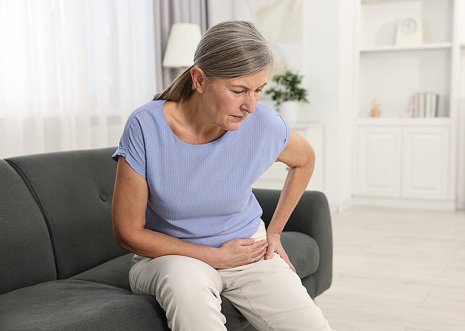 An elderly person experiencing a hip joint pain at home. — New Africa // Shutterstock