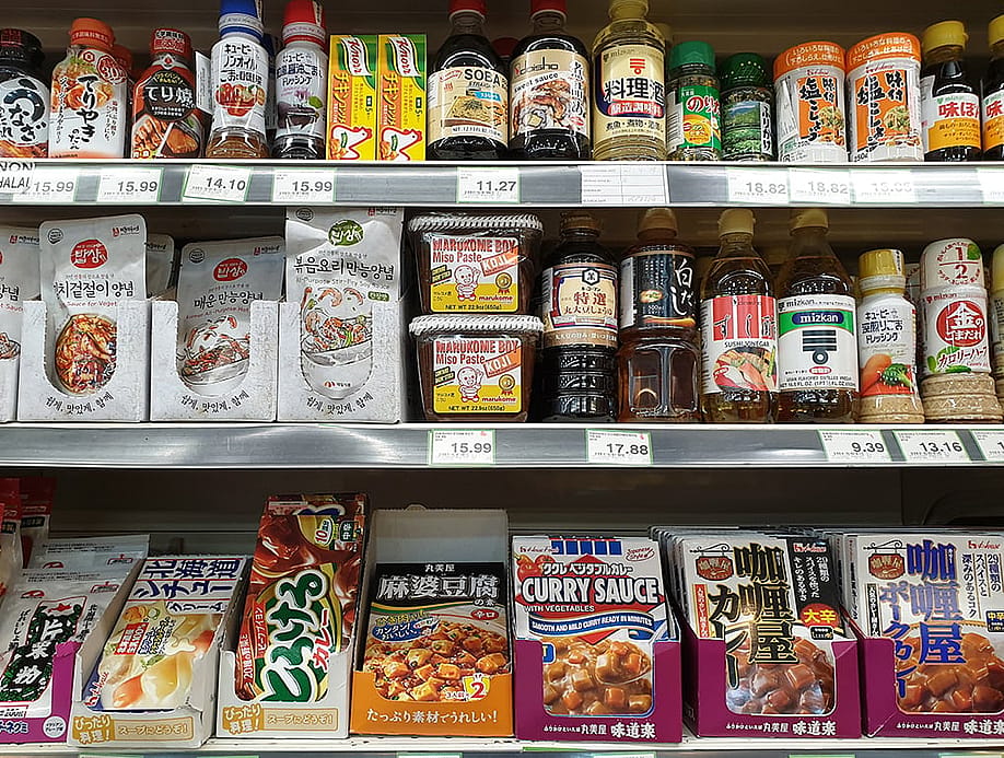 Assorted Asian imported foods and sauces in a grocery store shelf. — TY Lim // Shutterstock