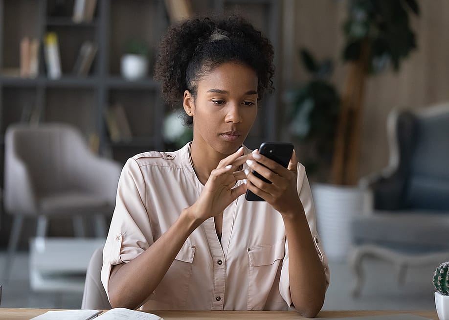 A focused young woman reviewing information on her smartphone. — fizkes // Shutterstock