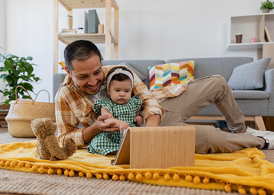 A father and his young daughter watching from a tablet. — PintoArt // Shutterstock