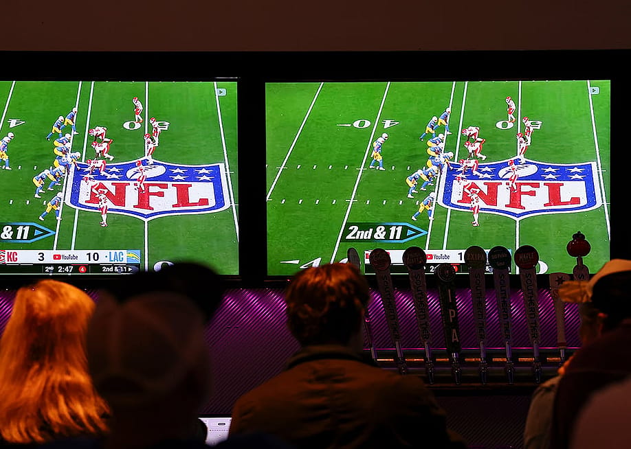 Bar patrons watch the YouTube TV telecast of the game between the Kansas City Chiefs and the Los Angeles Chargers on September 05, 2025 in Buffalo, New York. — Aaron M. Sprecher // Getty Images