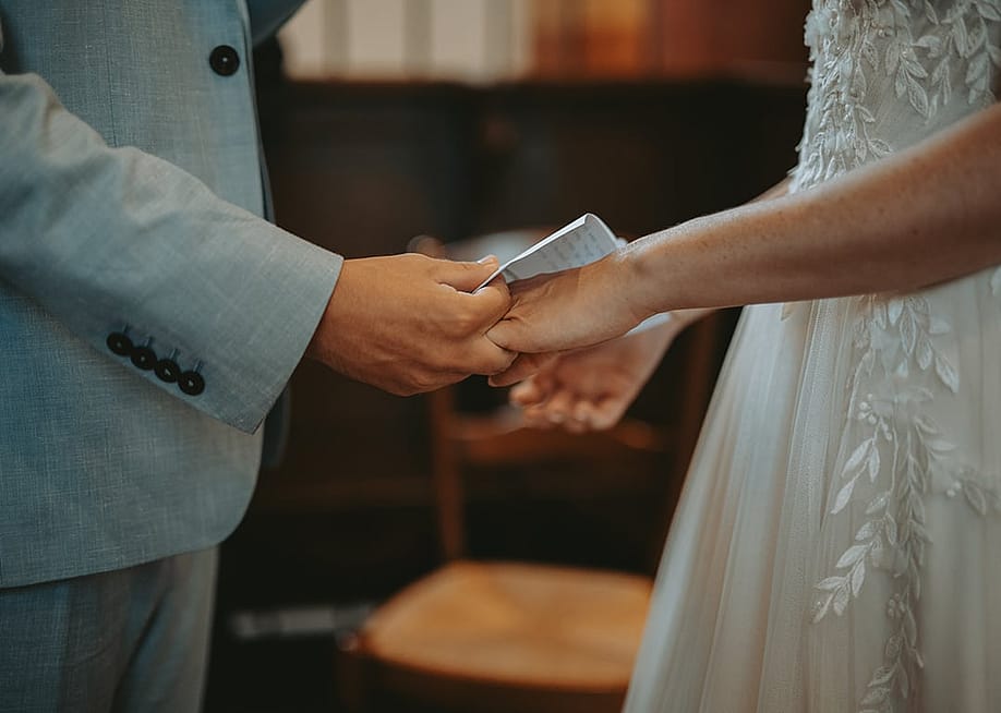 Closeup on a couple's hands exchanging wedding rings during a ceremony. — BAUER Alexandre // Shutterstock