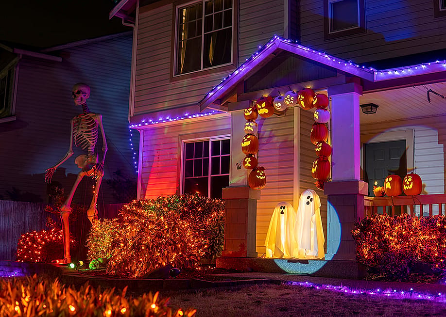 Exterior of a house illuminated with Halloween lights and decorations. — Summer_Wind // Shutterstock