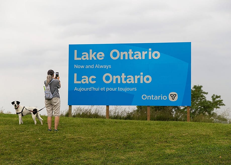 CANADA-ONTARIO-HAMILTON-LAKE ONTARIO-NAME A woman takes photos of an English-French bilingual sign reading "Lake Ontario Now and Always" at a lakeside conservation area in Hamilton, Ontario, Canada. — Zou Zheng // Xinhua via Getty Images